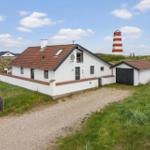 Moderne Villa mit Garage und Leuchtturm im Hintergrund