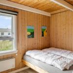Schlafzimmer mit Holzwand, Bett und Fensterblick auf Grasland.