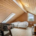 Zimmer mit zwei Betten, Tischfußball und Holzwandverkleidung