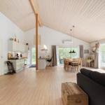 An open space with kitchen, dining area, and living area. Wooden floor and ceiling.