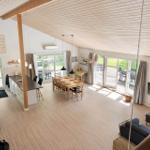 Large open space with kitchen, dining area, and living area. Wooden ceiling and terrace.