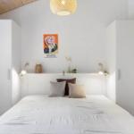 Bedroom with bed, white wardrobes, and wall posters.