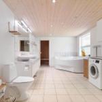 Bathroom with bathtub, washing machine, and dryer.