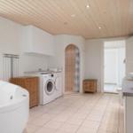 Bathroom with bathtub, washing machine, and shower