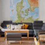 Living room with gray sofa, wooden table, and large wall map.