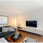 Wohnzimmer mit Sofa, Fernseher und Holzboden