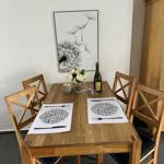 Holztisch mit vier Stühlen, Blumen und Platten auf Tisch
