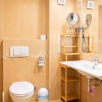 Badezimmer mit Toilette, Waschbecken und Spiegel