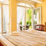 Schlafzimmer mit Bett, Schrank und Blick auf Balkon mit Garten.