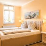 Schlafzimmer mit Bett, Fenster und Wandbild.