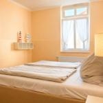 Schlafzimmer mit Bett, Fenster und Wandbild. Lampe und Dekoration an der Wand.