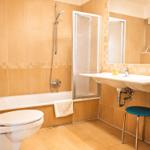 Badezimmer mit Badewanne, Dusche, Waschbecken und Toilette.