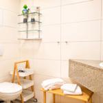 Badezimmer mit Toilette, Waschtisch und Handtuchständer.