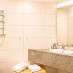 Badezimmer mit Waschtisch, Spiegel und Handtüchern