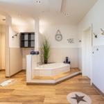 Bad mit Badewanne, Pflanze, Wanduhr und Holzboden