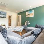 Wohnzimmer mit Sofa, Couchtisch und Fernseher an der Wand.