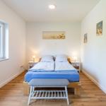 Schlafzimmer mit Doppelbett, Fenster und Strandmotiven an den Wänden.