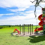 Kinderbereich mit Rutsche und Klettergerüst im Gras.