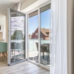 Terrasse mit Sitzgruppe und Blick auf Wohnhaus. Küchenbereich mit Esstisch und Stühlen.