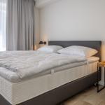 Schlafzimmer mit Doppelbett, Fenster und Nachttisch