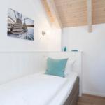 Schlafzimmer mit Einzelbett, Holzdecke und Wandbild mit Seil.