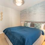 Schlafzimmer mit Bett, Wandtapete und Nachttisch