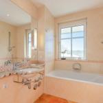 Bad mit Badewanne, Waschbecken und Fenster mit Blick.
