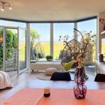 Wohn- und Essbereich mit Blick auf Garten und Hängesessel.