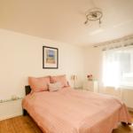 Schlafzimmer mit Bett, Schrank und Fenster. Wandbild und Beleuchtung sichtbar.