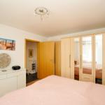 Schlafzimmer mit Bett, Kleiderschrank und Wandbild