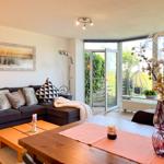 Wohnbereich mit Sofa, Esstisch und Blick auf Garten