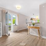 Helle Wohnung mit Holzboden, Fenster zum Garten und modernem Schreibtisch.