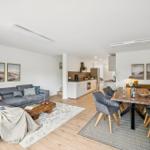 Wohn- und Essbereich mit Sofa, Esstisch und Küchenbereich.