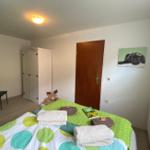 Schlafzimmer mit Bett, Kleiderschrank und Wandbild eines Hundes.