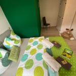 Schlafzimmer mit Bett, Kissen und Handtüchern. An der Wand ein grüner Bereich.