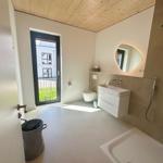 Badezimmer mit Dusche, Waschbecken und Toilette. Holzdecke und Fenster zur Außenterrasse.