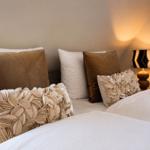 Ein Bett mit Kissen und einer Lampe an der Wand