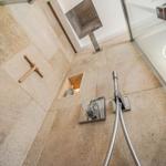 Dusche mit Steinwand, Duschbrause und Holzgriff