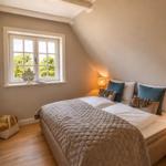 Schlafzimmer mit Dachschräge, Fenster, Bett und Nachttisch