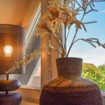 Tischlampe und Vasen mit Trockenblumen am Fenster