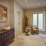 Flur mit Holzschrank, Wandbild, Sitzgelegenheit und Glaswand