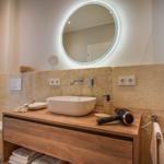 Badezimmer mit Waschbecken, Spiegel und Toilette