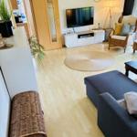 Wohnzimmer mit Sofa, Fernseher und Holzboden.