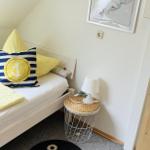 Schlafzimmer mit Bett, Kissen, Teppich und Wandbild.