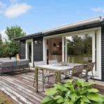 Deck with seating group and dining table. Sliding glass doors lead to kitchen-living area.