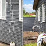 Outdoor shower on gray wooden house with window and wooden bench