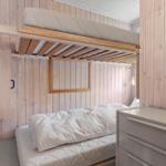 Room with two beds and wood-paneled walls.