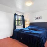 Schlafzimmer mit Bett, Fenster und Nachttisch