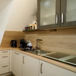 Küche mit Schrank, Spüle, Kochfeld und Kaffeemaschine