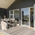 Terrasse mit Tisch, Stühlen und Blick ins Haus. Glastüren führen in den Innenraum.